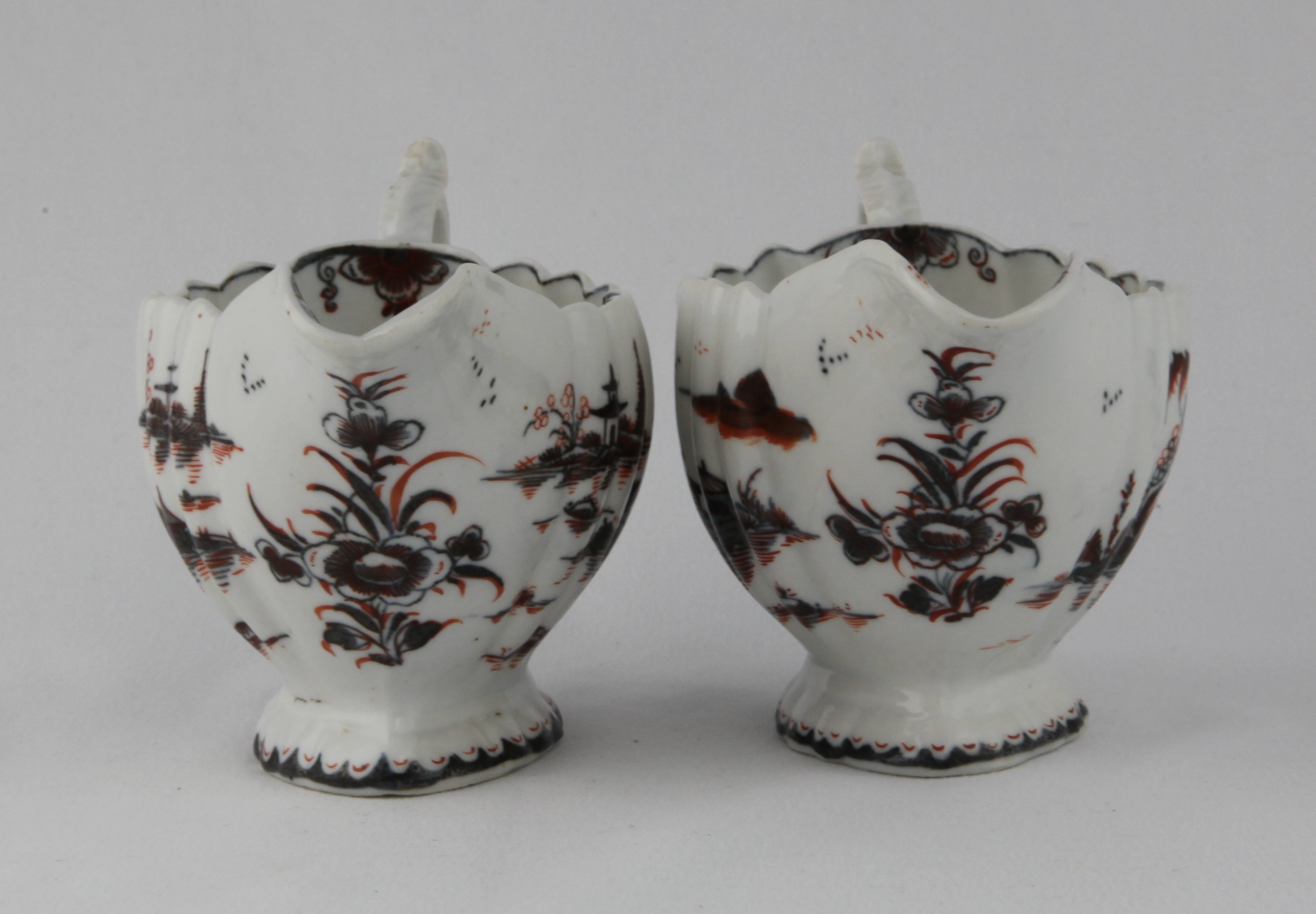 A near pair of Plymouth sauceboats with underglaze blue decoration picked out with red enamel